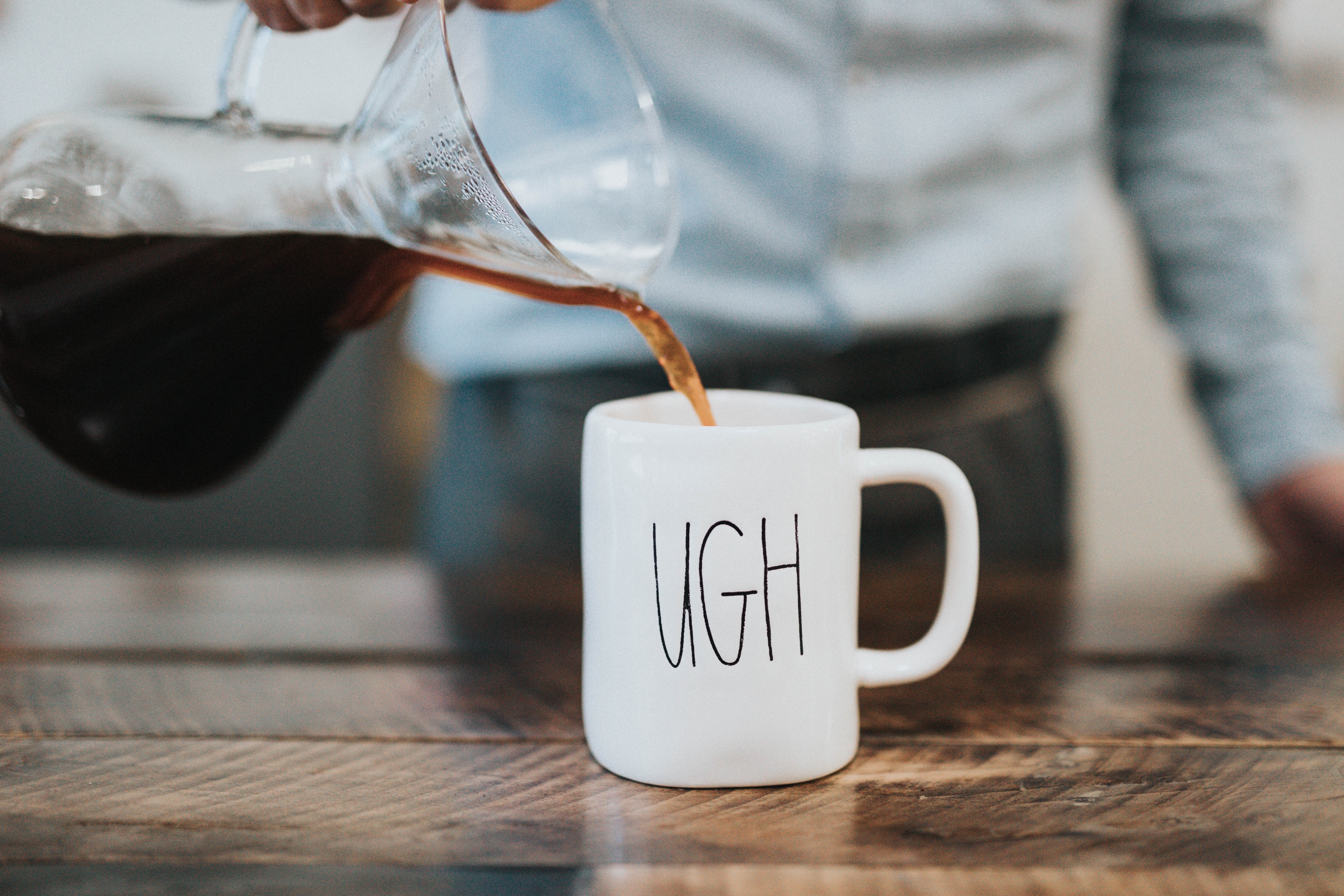 Photo by Nathan Dumlao on Unsplash [person pouring coffee into a mug with the word "ugh" written on it]